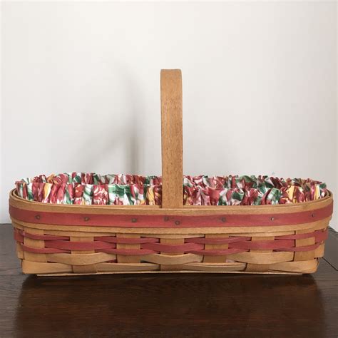  The basket is based on the 5" measuring form and has a single stationery oak handle. Most all handles on 1989 and prior years baskets were crafted from oak. The basket starts at the bottom with a 4" square and goes up 4.25" high to a round 5" diameter top. The handles adds another 4.25" for a total of 8.5" in overall height. 